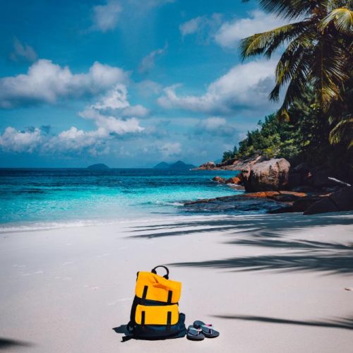 traveler-yellow-backpack-and-flip-flops-on-the-san-2023-11-27-05-25-28-utc.jpg